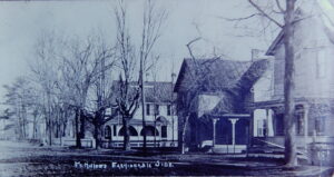 An old black and white photo of historic homes on a tree-lined street with the words "Fort Miller's Fashionable Side" handwritten on it.